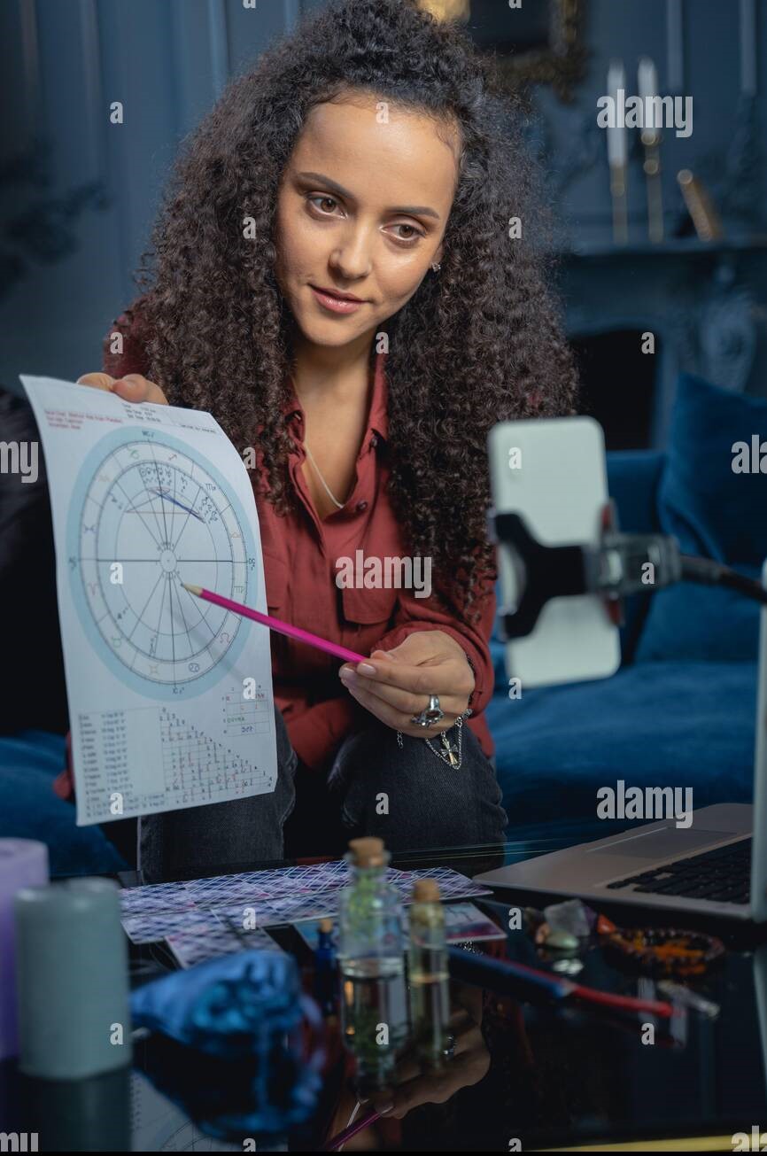attractive-female-astrologer-demonstrating-a-natal-chart-2AW8FC5